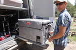 A guy standing by his Snomaster fridge on a slider pulled out.